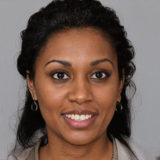 Joyful black young-adult female with medium  black hair and brown eyes