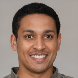 Joyful latino young-adult male with short  brown hair and brown eyes