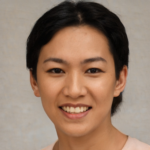 Joyful asian young-adult female with short  black hair and brown eyes