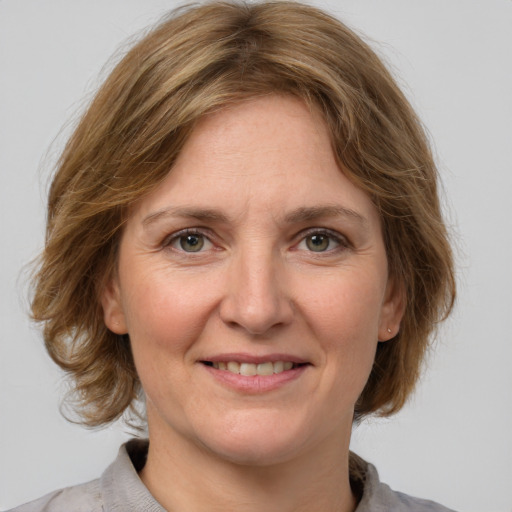 Joyful white adult female with medium  brown hair and grey eyes