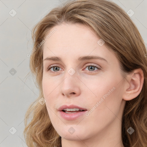 Joyful white young-adult female with long  brown hair and blue eyes