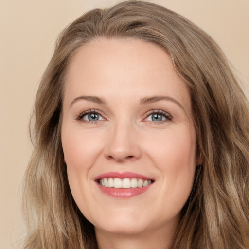 Joyful white adult female with long  brown hair and green eyes