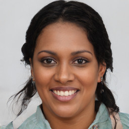 Joyful black young-adult female with long  brown hair and brown eyes