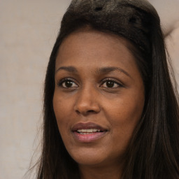 Joyful black young-adult female with long  brown hair and brown eyes