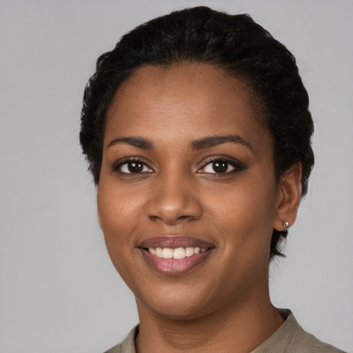 Joyful black young-adult female with short  black hair and brown eyes
