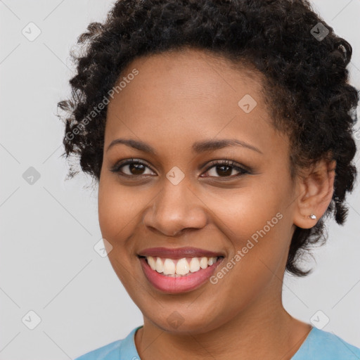 Joyful black young-adult female with short  brown hair and brown eyes