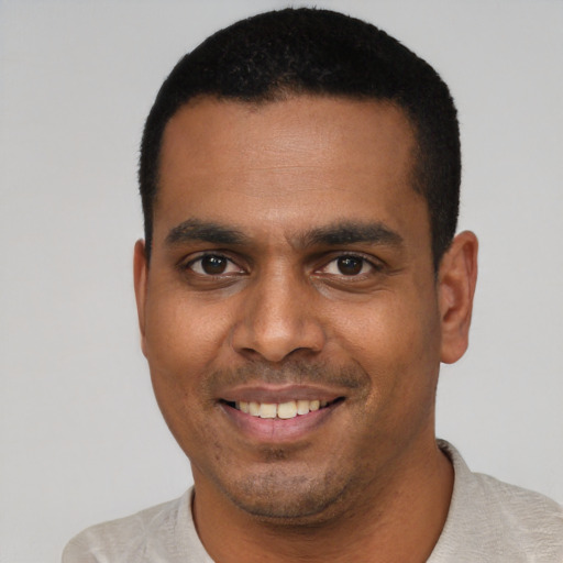 Joyful latino young-adult male with short  black hair and brown eyes
