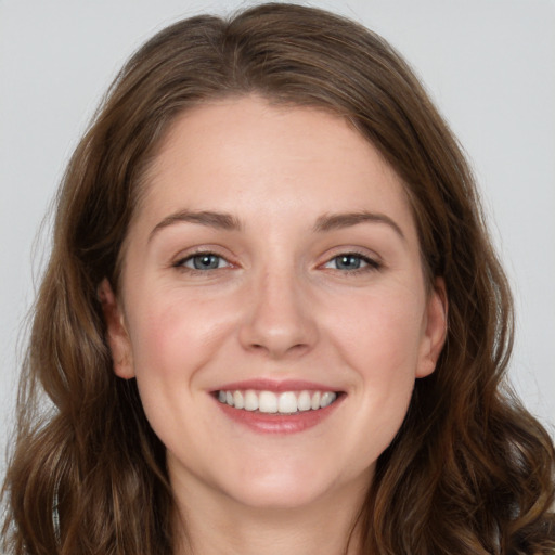 Joyful white young-adult female with long  brown hair and grey eyes