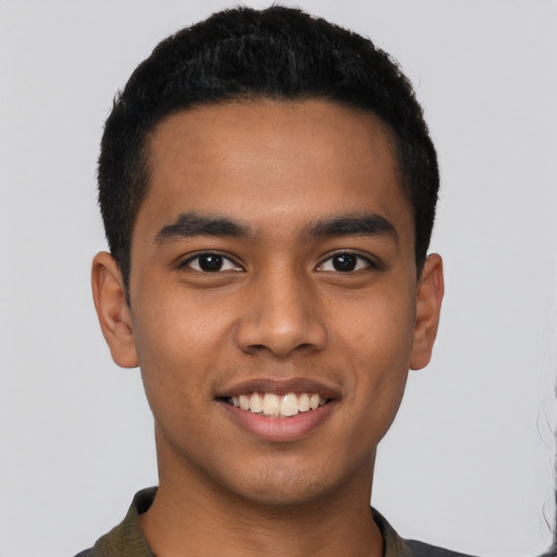 Joyful latino young-adult male with short  black hair and brown eyes