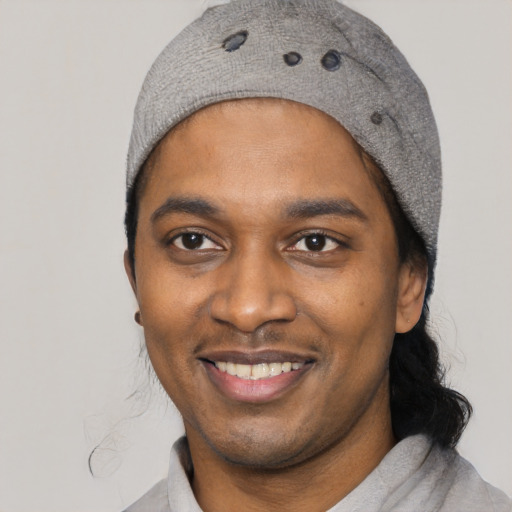 Joyful black young-adult male with short  black hair and brown eyes