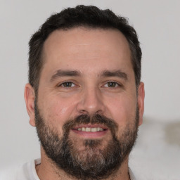 Joyful white adult male with short  brown hair and brown eyes