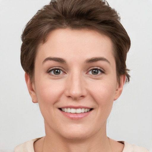 Joyful white young-adult female with short  brown hair and grey eyes