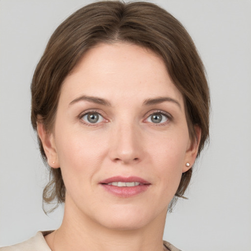 Joyful white young-adult female with medium  brown hair and grey eyes