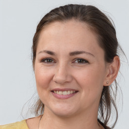 Joyful white young-adult female with medium  brown hair and brown eyes