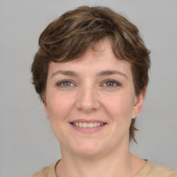 Joyful white young-adult female with medium  brown hair and grey eyes