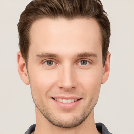 Joyful white young-adult male with short  brown hair and grey eyes