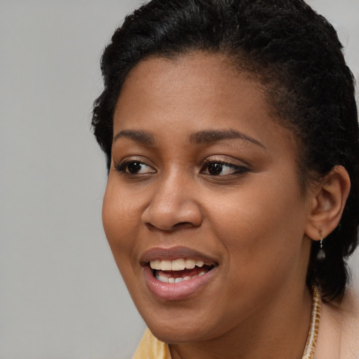 Joyful black young-adult female with long  brown hair and brown eyes