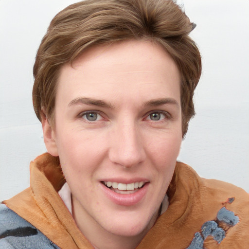 Joyful white young-adult female with short  brown hair and blue eyes