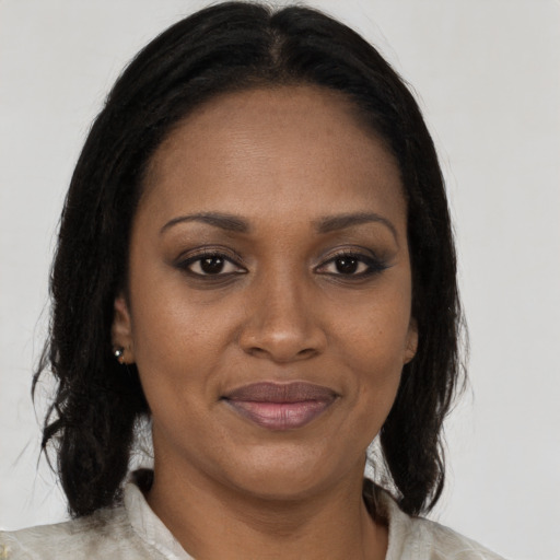 Joyful black adult female with medium  brown hair and brown eyes