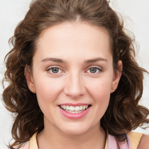 Joyful white young-adult female with medium  brown hair and green eyes