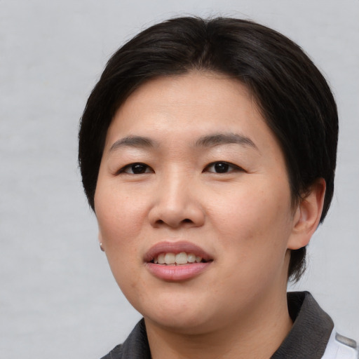Joyful asian young-adult female with short  brown hair and brown eyes