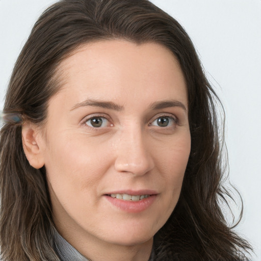 Joyful white young-adult female with long  brown hair and blue eyes