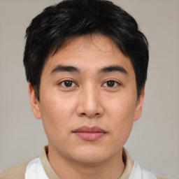 Joyful asian young-adult male with short  brown hair and brown eyes