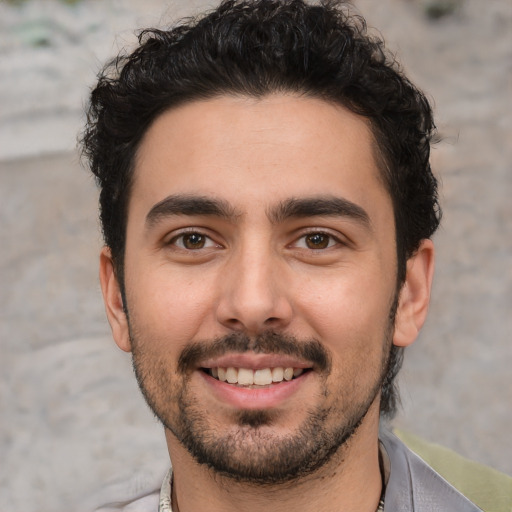 Joyful white young-adult male with short  black hair and brown eyes