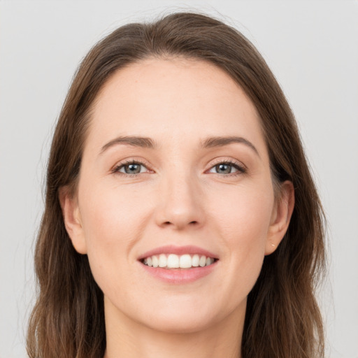 Joyful white young-adult female with long  brown hair and grey eyes