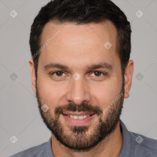 Joyful white adult male with short  brown hair and brown eyes