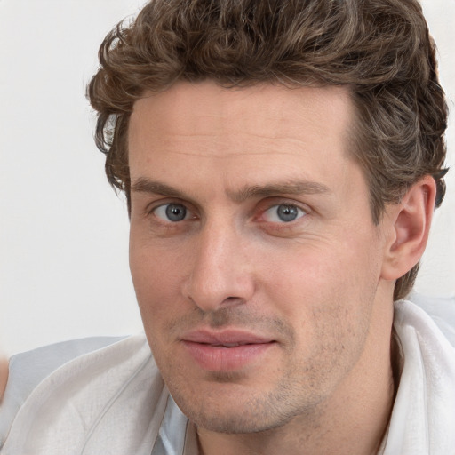 Joyful white adult male with short  brown hair and blue eyes