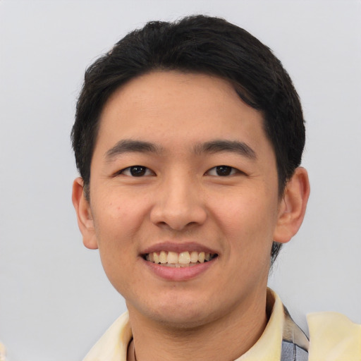 Joyful asian young-adult male with short  black hair and brown eyes