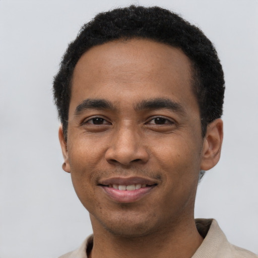 Joyful black young-adult male with short  black hair and brown eyes