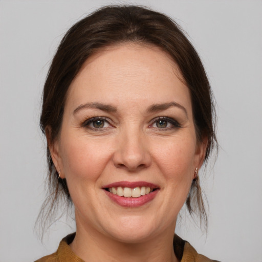 Joyful white adult female with medium  brown hair and brown eyes