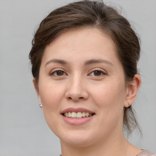 Joyful white young-adult female with medium  brown hair and grey eyes