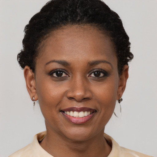 Joyful black young-adult female with short  black hair and brown eyes