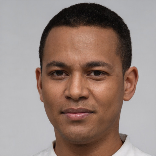 Joyful black young-adult male with short  brown hair and brown eyes