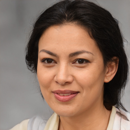 Joyful latino adult female with medium  brown hair and brown eyes