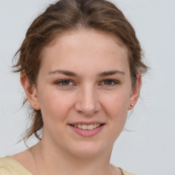 Joyful white young-adult female with medium  brown hair and grey eyes