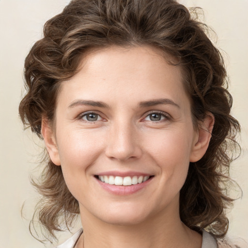 Joyful white young-adult female with medium  brown hair and green eyes