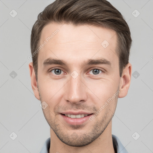 Joyful white young-adult male with short  brown hair and grey eyes