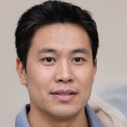 Joyful asian young-adult male with short  black hair and brown eyes