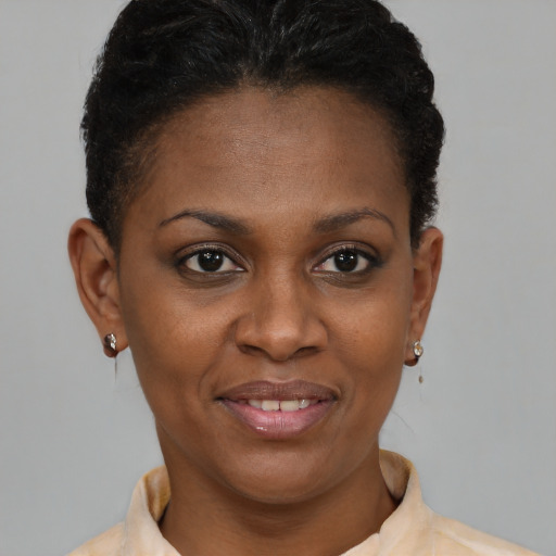 Joyful black young-adult female with short  brown hair and brown eyes
