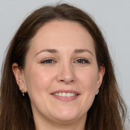 Joyful white adult female with long  brown hair and grey eyes