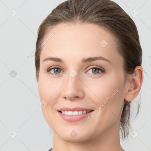 Joyful white young-adult female with medium  brown hair and grey eyes