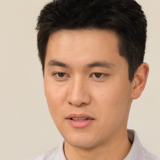 Joyful asian young-adult male with short  brown hair and brown eyes