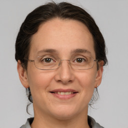 Joyful white adult female with medium  brown hair and grey eyes