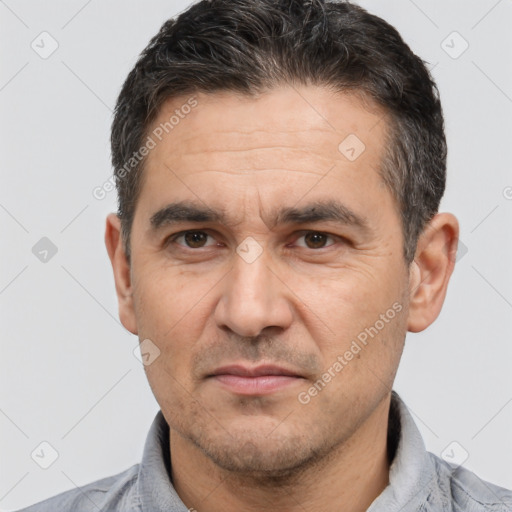 Joyful white adult male with short  black hair and brown eyes