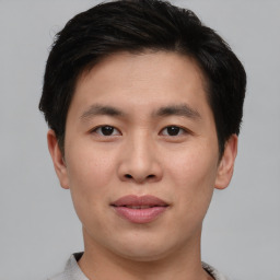 Joyful asian young-adult male with short  brown hair and brown eyes