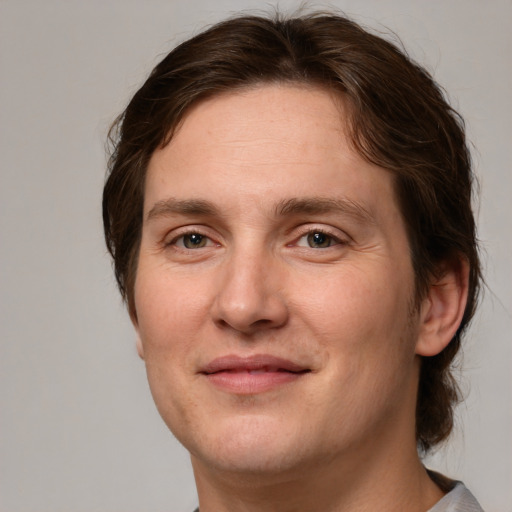 Joyful white adult male with medium  brown hair and grey eyes